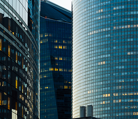 Night architecture - skyscrapers with glass facade. Modern buildings in Paris business district. Evening dynamic traffic on a street. Concept of economics, financial.  Copy space for text. Toned